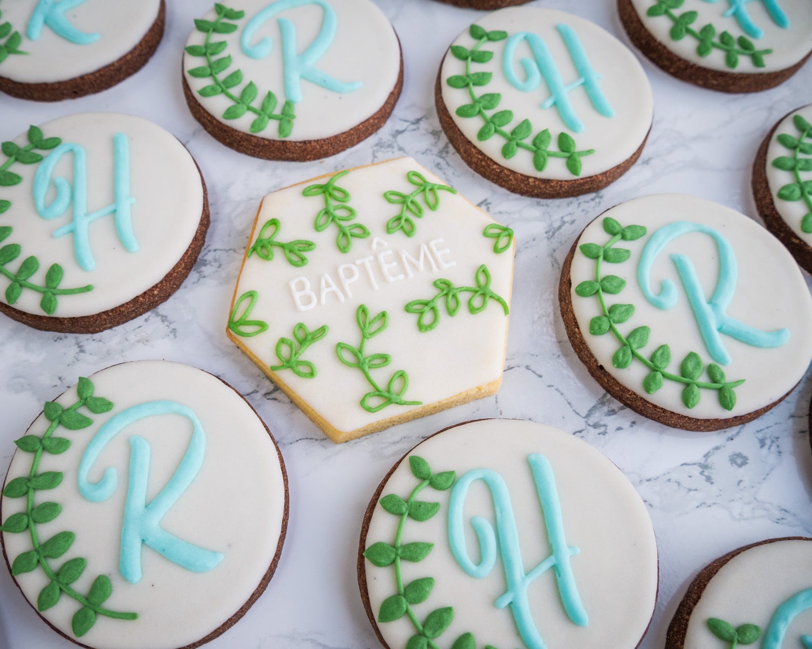 biscuit avec écrit baptême et des branches de feuilles